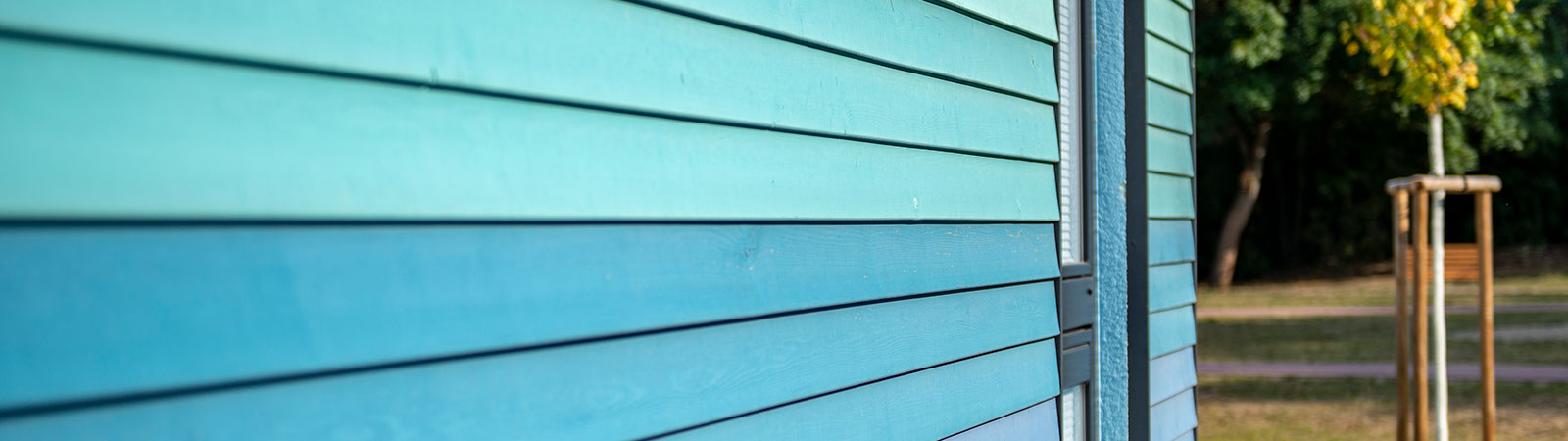 Osmo Anstriche und Farbe in vielen Varianten – eine Holzfassade ist mit Osmo in verschiedenen Blautönen gestrichen worden. Die Farben sind sehr Ergiebig