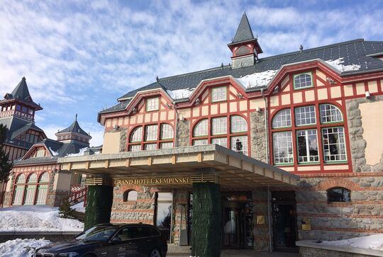 Die Holzbalken um die Fenster des Grand Hotel Kempinski Eingangs erstrahlen im satten Rot der Landhausfarbe von Osmo – Referenz