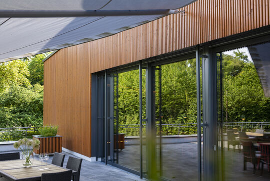 Osmo Referenz – Terrasseneingang des Weinguts Klumpp mit Glastüren und senkrechter Holzfassade
