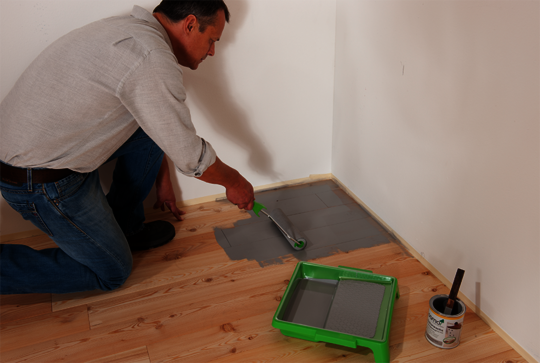 Sand the wooden floor, then coat the corners and edges with Osmo Dekorwachs in the desired colour and buff it in.