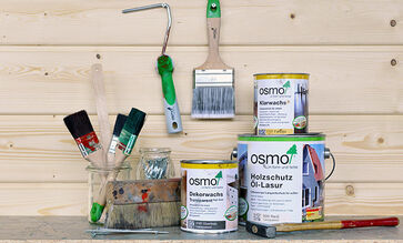 eine Auswahl von Osmo Produkten und Zubehör vor einer Profilholzwand