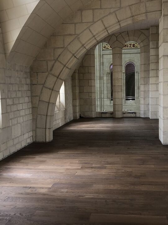 Der dunkel braune und mit Osmo Hartwachs-Öl behandelte Holzboden der Kirche steht im Kontrast mit der weißen Steinfassade – Osmo Referenz