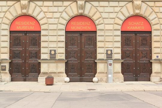 Das Innenstadtschloss München beeindruckt mit seinen drei Eingangstoren aus Holz und dem Kontrast zu der Grünsandstein-Fassade – Osmo Referenz und Osmo Produkte