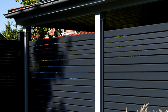 Privacy screen Osmo Alu-Fence Rhombus in anthracite grey hides views onto the carport.