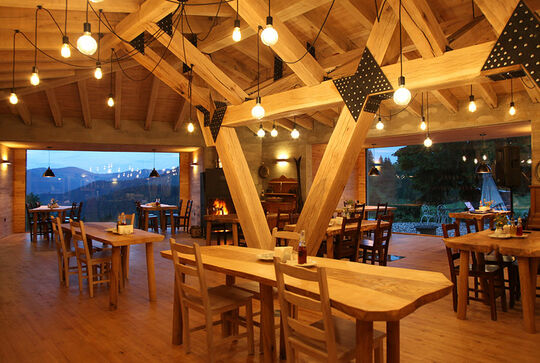 Holzbalken verbinden den Holzfußboden mit der Decke in Form eines Vs – Inneneinrichtung aus Holz mit schöner Aussicht – Osmo Referenz Hotel Gela