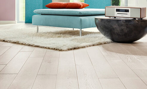 Weißgefärbter Fußboden aus Eichenholz von Osmo sorgt für ein modernes Wohnzimmer.