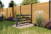 Osmo Green-Fence in Anthrazit steht als Pflanzgefäß und Sichtblende in einem eingezäunten Garten
