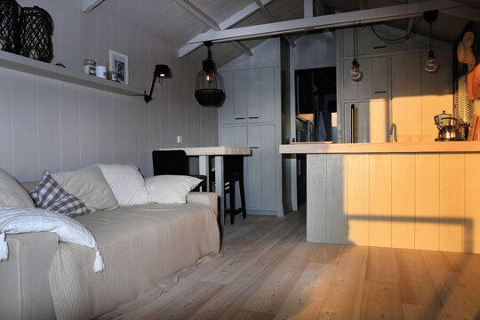 Der Wohnbereich des Tiny Houses mit Holzfußboden und Holzverkleidung – Osmo Referenz Tiny Houses