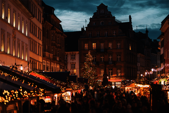 Besucher schlendern durch den Weihnachtsmarkt am See in Konstanz