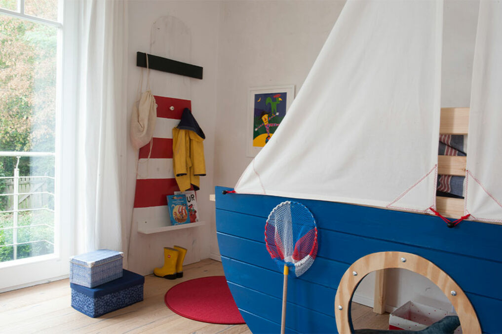 children’s bedroom in maritime style: sailboat loft bed in Osmo Dekorwachs and lighthouse shelf