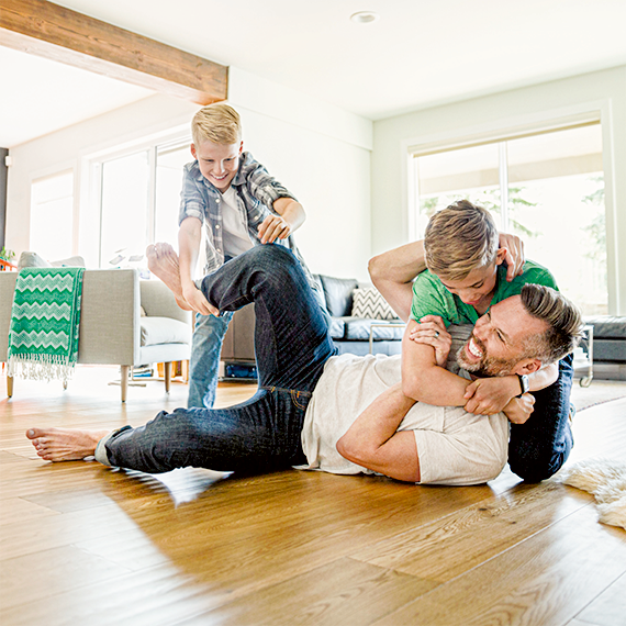 Father and two children playing in the living room