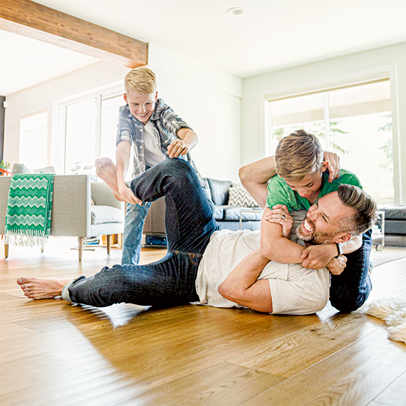 Vater mit zwei Kindern spielen im Wohnzimmer