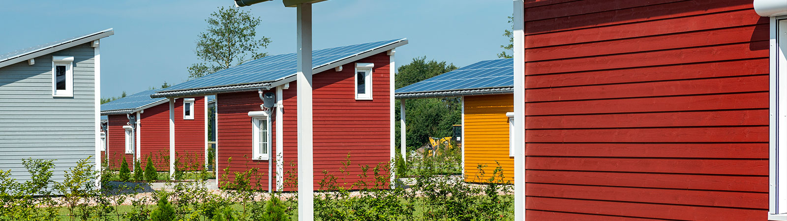 Osmo Beschichtungssysteme für Gartenhäuser und Carports außen – Ferienhäuser mit roter Holzfassade – industrielle Anwendung