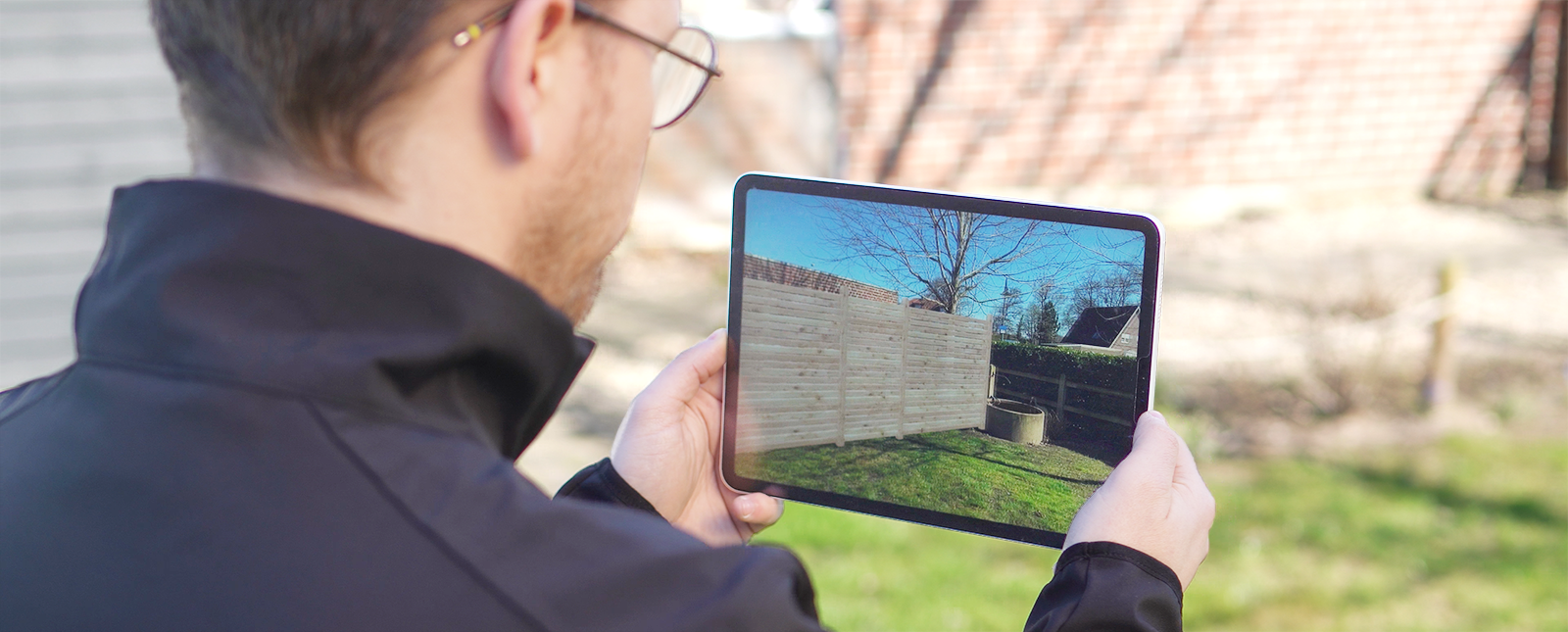 Mann plant seinen Sichtschütz im eigenen Garten mit Osmo Sichtblendenkonfigurator